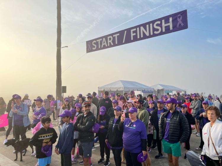 A large crowd of people walking through the finish line of the Team Spirit walk. 