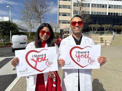 Nissi Suppogu, M.D., and Aditya Prasad, M.D., stand together at the MemorialCare Heart & Vascular Institute at Long Beach Medical Center, proudly holding their “I Stand 4 You” cards to raise awareness for women’s heart health.