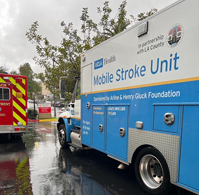 The "mobile stroke unit" sitting in the parking lot of a hospital with the ground wet from the rain. 