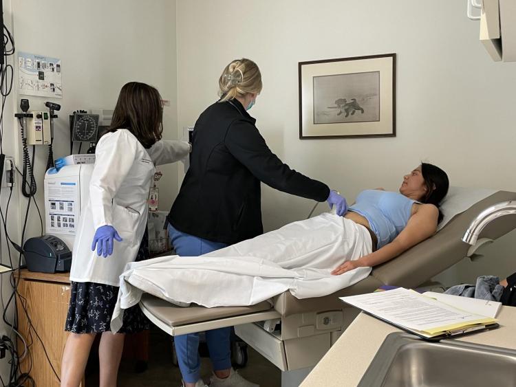 A registered nurse and Dr. Swords perform an ultrasound on an expecting mother. 
