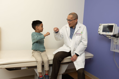 Dr. Graham Tse with young patient in clinic.