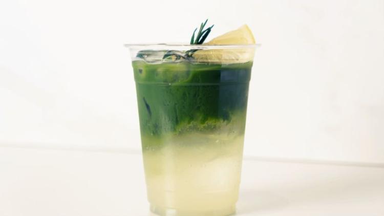 A matcha tonic mocktail in a plastic cup