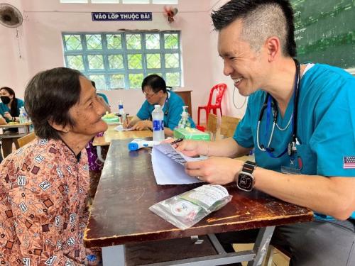 Vinh Nguyen, M.D., family medicine physician, chief medical information officer, MemorialCare Medical Group-Huntington Beach, and a patient exchange smiles during a clinic visit, as he reviews medical notes and provides guidance on care.  