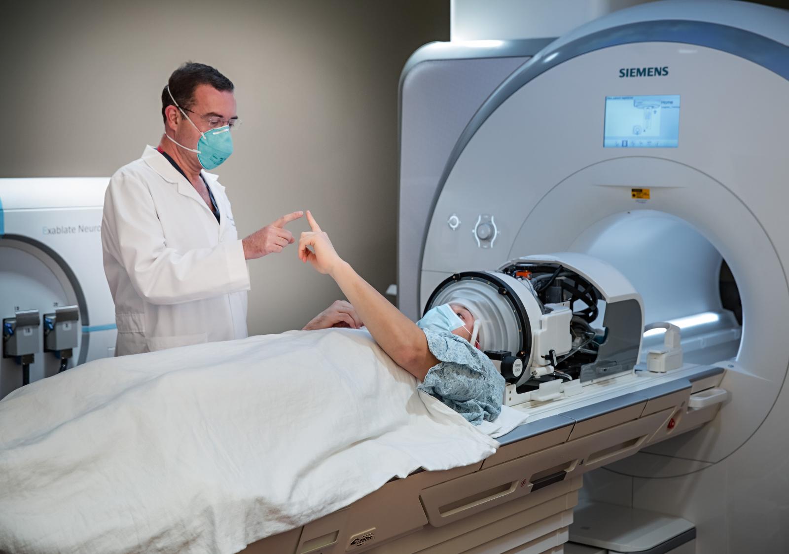 Devin K. Binder, M.D., Ph.D., is using the latest technology for MR-guided Focused Ultrasound procedures on a patient.